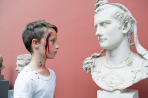 Dreng med gladiatorsår fra Glyptotekets romerske børneværksted kigger på den romerske kejser Caligula.