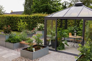 Hyggeligt havehjørne med Land Modern plantekasser og bænke, samspil med drivhus
